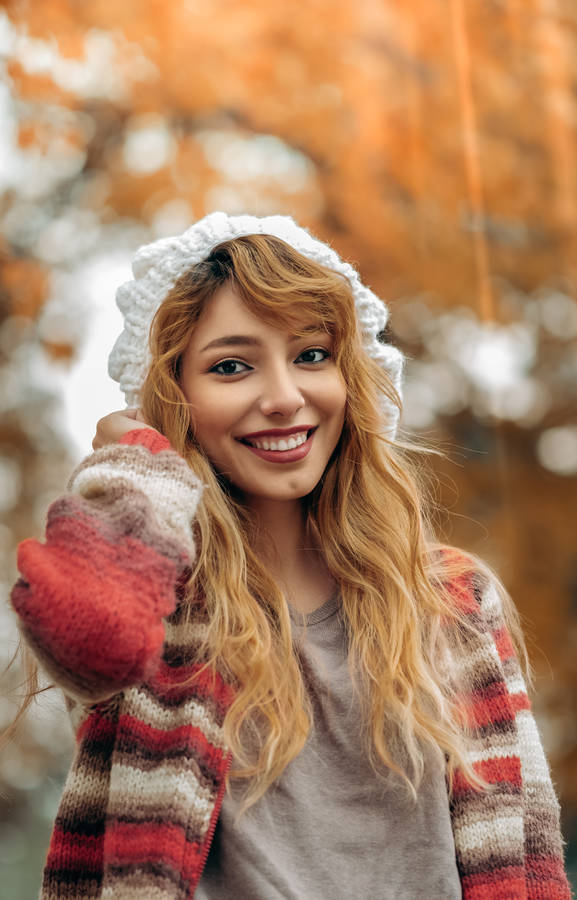 A portrait of a girl wears a fall outfit with blurred orange trees in the background HD wallpaper