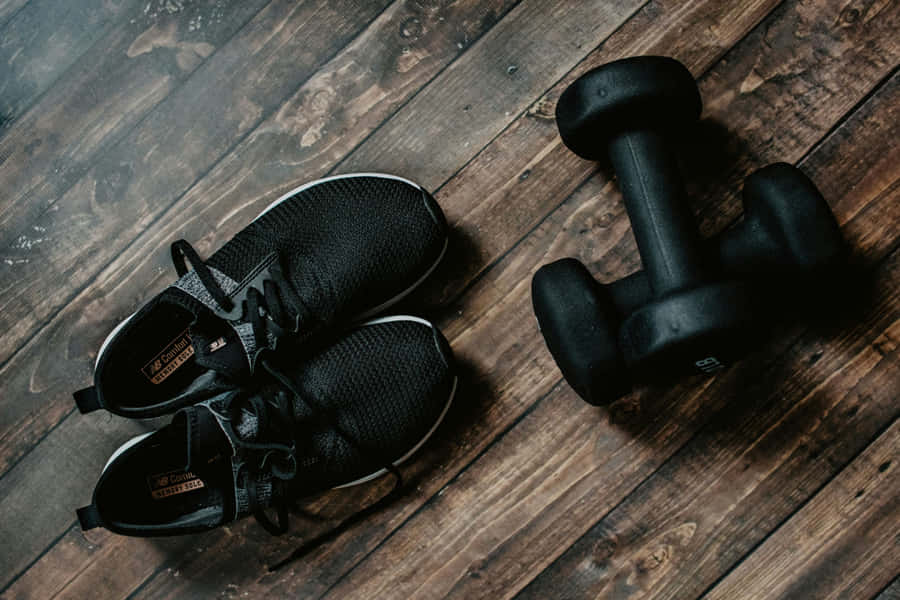 Fitness Ready Sneakersand Dumbbellson Wooden Floor